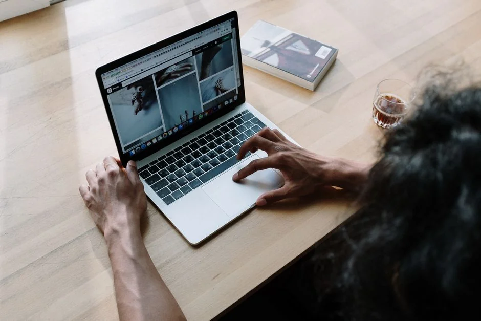 Two businessmen analyze stock market data using a smartphone and laptop in a modern office setting.